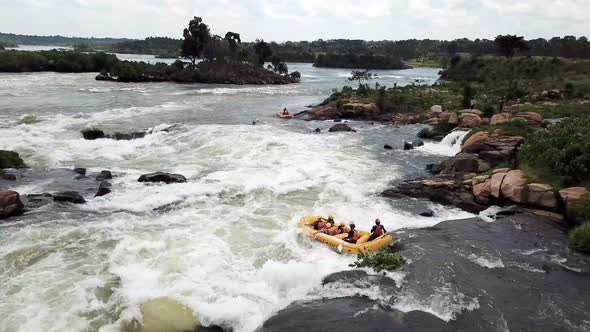Drone view of a yellow boat white water rafting down the falls of the Nile River in Jinja, Uganda.