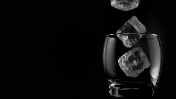 Ice cubes falling in super slow motion in a glass