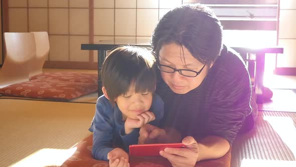 Asian Father Using Smartphone With His Son2