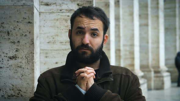 Peaceful young latin man making asking plesure gesture at camera in the street