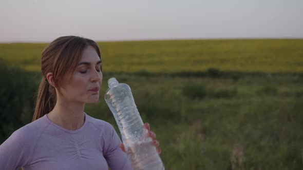 Thirtsty Girl Drinks Water After Her Workout