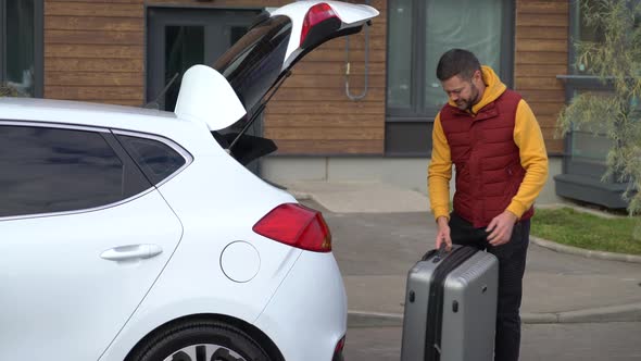 Man takes luggage out of the car