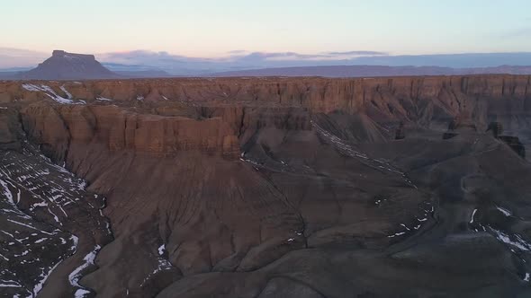 Flying over rugged terrain in the Utah desert at sunrise