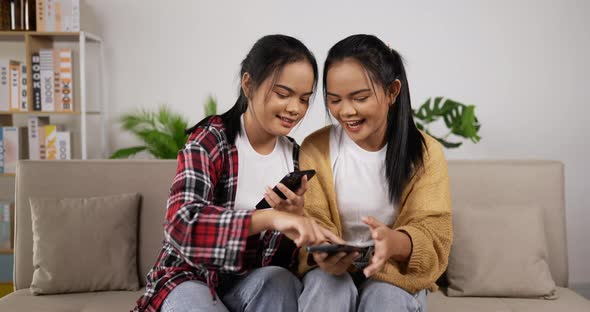 Asian twin girls playing smartphone on phone