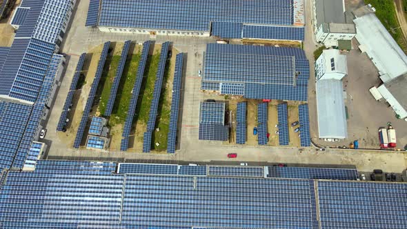 Aerial view of blue photovoltaic solar panels mounted on building roof for producing clean