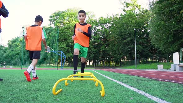 Football Uniforms Doing Running Exercises with Overcoming Obstacles Under Command