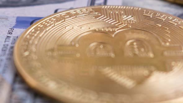 Gold bitcoin coin on 100 dollar bill rotates.