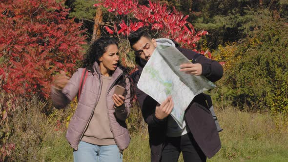 Annoyed Hispanic Couple Arguing About Right Direction Route Looks at Paper Map Using Navigation
