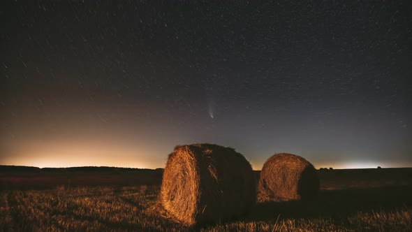 Comet Neowise C2020F3 In Night Starry Sky Above Haystacks In Summer Agricultural Field. Stars Above