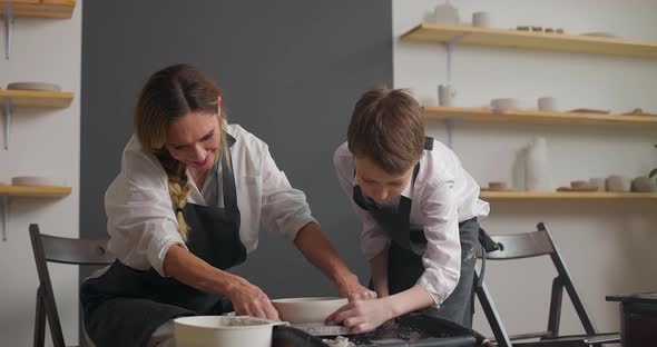 Mother Teaches Her Son Working on a Pottery Rotating Wheel