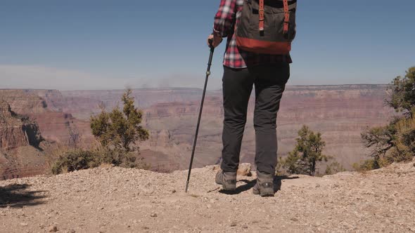 Tourist Walks The Edge Of Grand Canyon Cliff And Raises Her Arms Up Enjoying