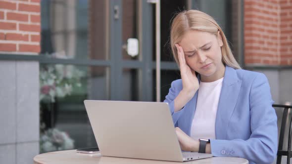 Businesswoman with Headache Using Laptop, Sitting Outdoor