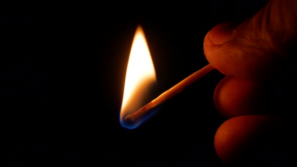 Lighting a match against a matchbox in the dark