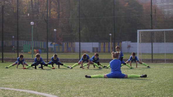 Soccer Players Doing Stretching During Training