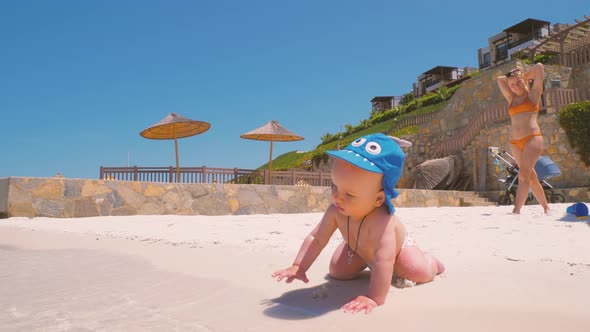 For the First Time, a Child Near the Ocean with His Mother Touches Salt Water 