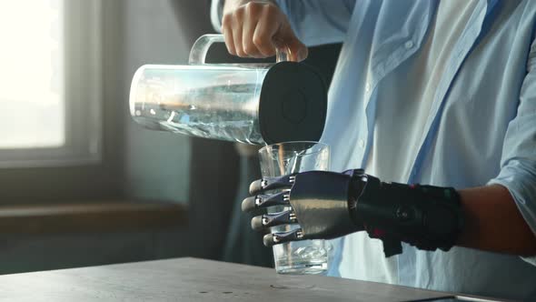 Cyborg guy with artificial limb pours water into glass from large bowl