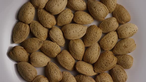 Cinematic, rotating shot of almonds on a white surface