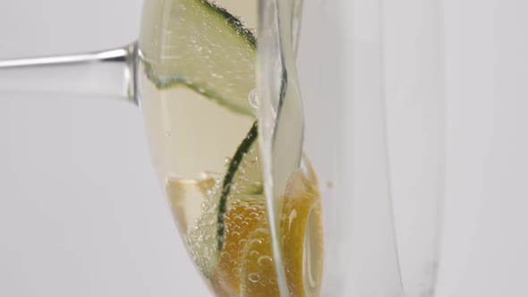 Vertical video, Close-up: lemon in a glass of bubbling champagne with cucumber