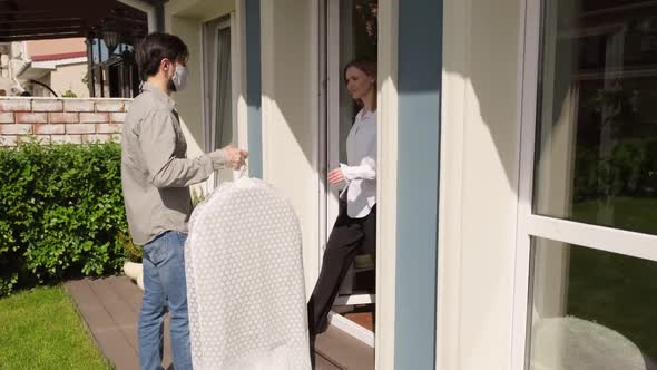 Young Man in Face Mask Delivering Dry Cleaning