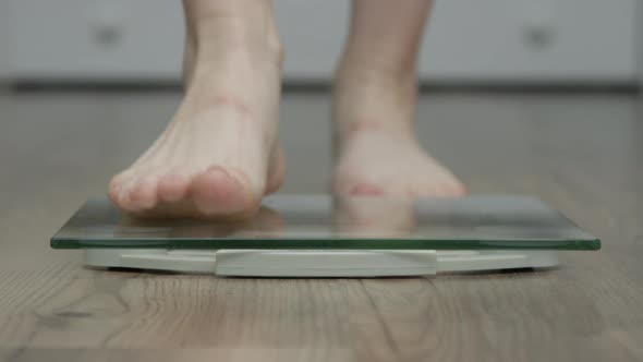 Woman Stands On The Scales To Check Her Weight