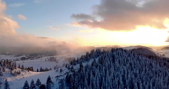 Foggy Sunset Over Winter Mountains With Snow-Covered Pine Trees - Aerial Drone Shot, Hyperlapse