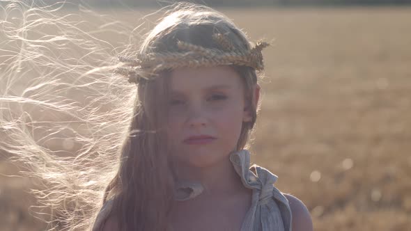 Serious Sad Girl a Child Stands on a Wheat Mown Field