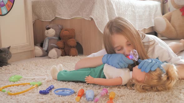 Beautiful Little Girl Playing Doctors with Doll at Home