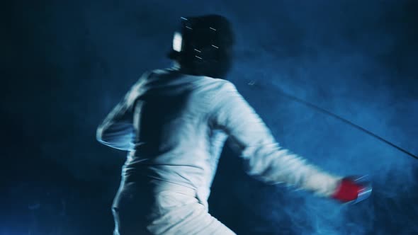 Male Athlete is Fencing with His Opponent