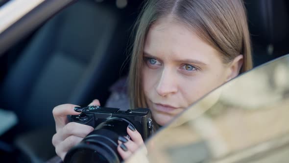 Closeup Female Spy Taking Photos with Camera Sitting in Car on Driver's Seat
