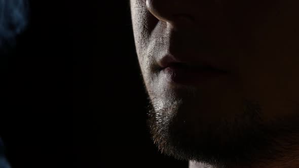 Shots of a Man Smoking a Cigarette Blowing Smoke. Black. Close Up