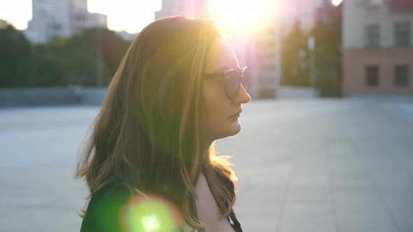 Profile of Young Business Woman in Sunglasses Walking in City Street. Attractive Businesswoman