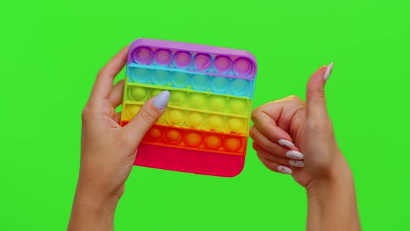 Closeup of Girl Hands Playing Squeezing Antistress Toys Simple Dimple Game Isolated on Chroma Key