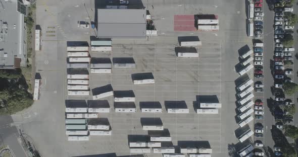 Static aerial perspective looking down over how bus depot is organized while one machine navigates t