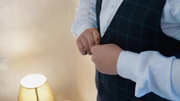 A Man Puts on a Suit Close Up