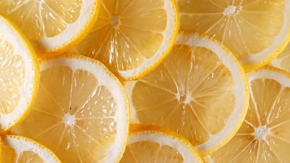 Slow Motion of Fresh Lemons Slices on Yellow Background