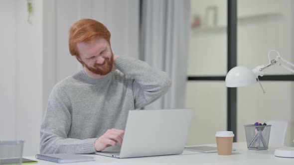 Beard Redhead Man Having Neck Pain While Typing on Laptop