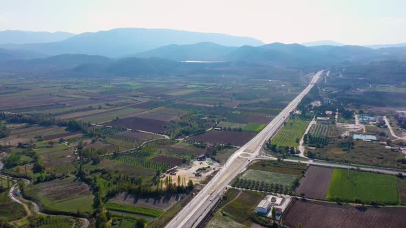 Aerial View of Country Road Along Agricultural Fields on a Summer Day