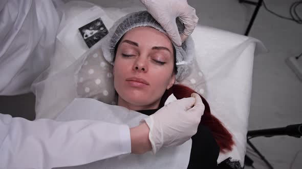 The Girl is Lying on the Couch the Beautician Corrects Her Hat the Girls are Preparing for Permanent