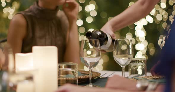 Waiter Pouring Red Wine in Woman Glass While People, Talking,eating,drinking During Romantic Gourmet