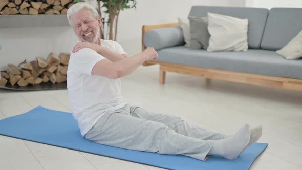 Old Man Having Shoulder Pain on Yoga Mat at Home