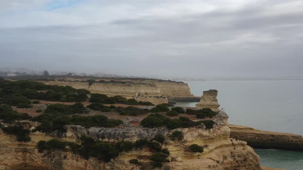 Fontainhas Beach in South Portugal with eroded rock formations over the Atlantic ocean, Aerial flyov