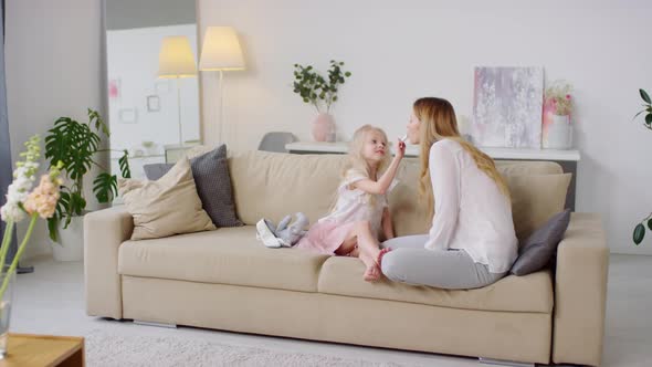 Sequence of Happy Girl Putting Lipstick on Mother