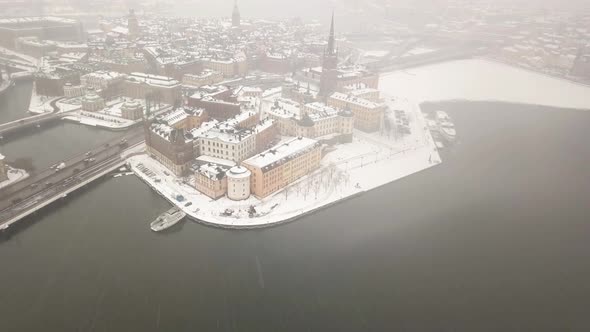 Wide angle drone footage of old city skyline while slowly zooming in on prime waterfront property