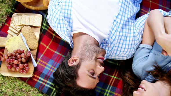 Couple lying on picnic blanket