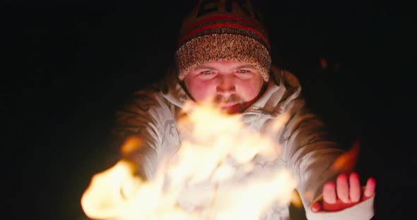 Man Feeling Cold on Autumn Night. Handsome Tourist Warming Hands By the Campfire