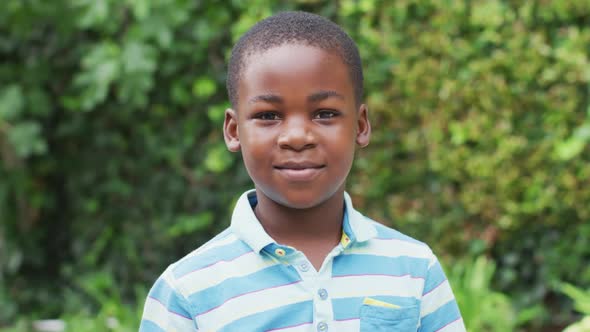 Animation of happy african american boy looking at camera in garden