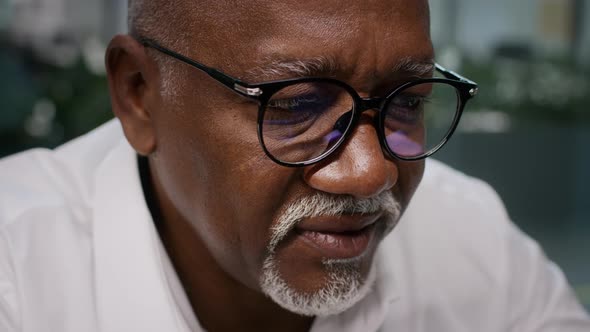 Closeup Shot Of Black Mature Businessman Wearing Eyeglasses Reading On Computer Screen