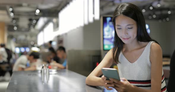 Woman Using Mobile Phone in Coffee Shop at Night 