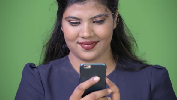 Young Overweight Beautiful Indian Businesswoman Against Green Background