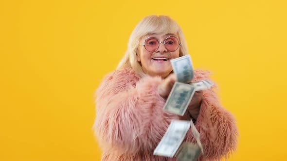 Excited Aged Lady Throwing Dollar Bills Around, Lottery Win Financial Investment